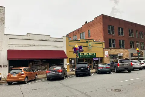 A small-town main street with shops and parked cars